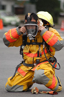US Navy 031213-N-8937A-064 A fire fighter assigned to Commander U.S. Naval Forces Japan (CNFJ) Regional Fire Department dons protective equipment.jpg
